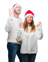 Sticker - Middle age hispanic couple wearing christmas hat over isolated background relax and smiling with eyes closed doing meditation gesture with fingers. Yoga concept.