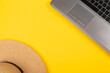 © Hanna - Laptop and straw hat on yellow background. Work at holiday. Concept of travelling on summer vacation. Business trip to the south. Freelancer's job. Working weekend. Visiting card with empty space
