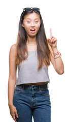 Wall Mural - Young asian woman wearing sunglasses over isolated background pointing finger up with successful idea. Exited and happy. Number one.