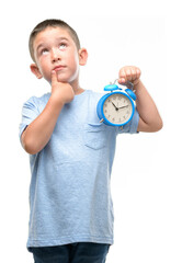 Wall Mural - Little child holding alarm clock serious face thinking about question, very confused idea