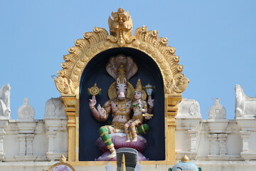 Wall Mural - Avatar Vishnu Hayagriva with Lakshmi on the roof of a Hindu temple in India.