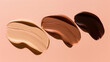 flat lay of three pastel beige and , dark brown and brown liquid foundation swatches on a pastel peach color background, with a soft shadow effect, minimalist aesthetic, hard shadows
