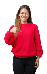 Poster - Young beautiful brunette woman wearing red winter sweater over isolated background doing happy thumbs up gesture with hand. Approving expression looking at the camera showing success.