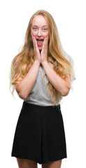 Poster - Blonde teenager woman wearing moles shirt afraid and shocked with surprise expression, fear and excited face.