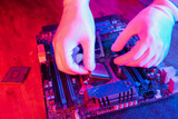 Fototapeta  - Technician laying CPU into the motherboard socket Computer service and upgrade concept. Processor close up in neon light