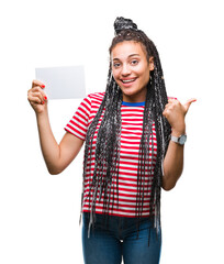 Poster - Young african american girl holding blank card over isolated background pointing and showing with thumb up to the side with happy face smiling