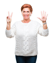 Canvas Print - Atrractive senior caucasian redhead woman wearing winter sweater over isolated background showing and pointing up with fingers number seven while smiling confident and happy.