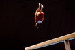 female gymnast perform backward somersault exercise on balance beam gymnastics