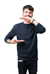 Wall Mural - Young handsome man over isolated background gesturing with hands showing big and large size sign, measure symbol. Smiling looking at the camera. Measuring concept.