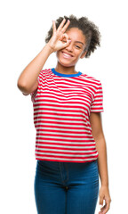 Wall Mural - Young afro american woman over isolated background doing ok gesture with hand smiling, eye looking through fingers with happy face.