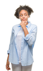 Wall Mural - Young afro american woman over isolated background looking confident at the camera with smile with crossed arms and hand raised on chin. Thinking positive.