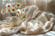 Daisies in a vase on a knitted blanket in sunlight, great for home decor and lifestyle use.