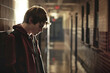 Sad, lonely and depressed teen age boy at school, frustrated after bullying. Mental health, tired and unhappy student in the corridor after problem in class, education fail and social isolation.