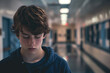 © Ekaterina Pokrovsky - Sad, lonely and depressed teen age boy at school, frustrated after bullying. Mental health, tired and unhappy student in the corridor after problem in class, education fail and social isolation.