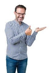 Wall Mural - Handsome middle age elegant senior man wearing glasses over isolated background Showing palm hand and doing ok gesture with thumbs up, smiling happy and cheerful