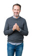 © Krakenimages.com - Handsome middle age senior man wearing a sweater over isolated background Hands together and fingers crossed smiling relaxed and cheerful. Success and optimistic