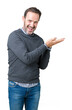 © Krakenimages.com - Handsome middle age senior man wearing a sweater over isolated background Pointing to the side with hand and open palm, presenting ad smiling happy and confident