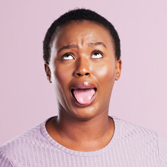 Wall Mural - Black woman, face and tongue out in studio with funny for comic meme, silly comedy and eye roll. African girl, pink background and crazy emoji with mouth for weird expression and wild or goofy person