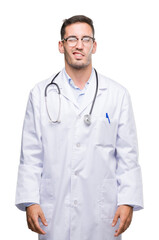 Canvas Print - Handsome young doctor man winking looking at the camera with sexy expression, cheerful and happy face.