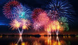 Colorful fireworks lighting up the night sky with reflections on water surface. 4th of July, Independence day background