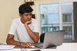 © gamerxtc - indian young man working at home with laptop computer and notepad