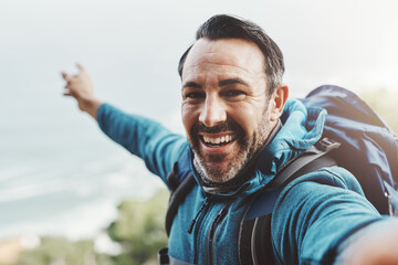 Selfie, hiking and man with nature, travel and excited with happiness, adventure or environment. Portrait, person or hiker with profile picture, health or vacation with journey, getaway trip or smile