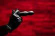 © Granmedia - Silicone anal vibrator in female hands in black latex gloves on a red background. Massager with multiple speeds. Sex shop products, adult gifts for couples.