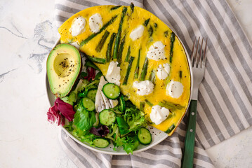 Poster - Omelet with asparagus and goat cheese on a plate with avocado and green salad