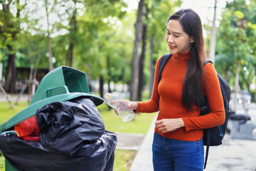 Wall Mural - woman is throwing away trash and holding a bottle