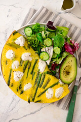 Poster - Omelet with asparagus and goat cheese on a plate with avocado and green salad