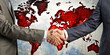 Two people shake hands in front of a world map with the continents represented by red dots of paint. The background suggests the concept of global business or international agreements.AI generated.