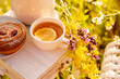 drinking tea in a sunny summer garden. tea and bun close-up among yellow vets