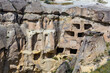 Imposing view of ancient multi-level cave dwellings carved into a rocky cliff in Cavusin, for historical and geological studies. Cavusin, Cappadocia, Turkey (Turkiye)
