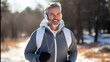 Keeping in shape at any age. A middle-aged man with a beard during a winter run to his favorite music. Healthy lifestyle and privacy.