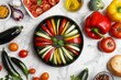 Colorful assortment of fresh ingredients prepared for gourmet ratatouille on a chic white marble table