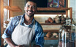© peopleimages.com - Cafe, portrait and happy man waiter in bakery for store welcome, help and friendly hospitality service. Retail, startup and coffee shop or restaurant server with cake, cookies or counter assistance