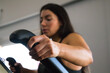 Detail of the hand of a young and beautiful brunette woman training on an elliptical treadmill in a cardiovascular workout. Health and sport concept.