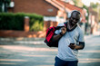© Geber86 - Happy man with gym bag and headphones using smartphone