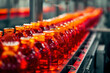 Row of red bottles on conveyor belt in industrial factory production line