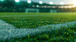 Closeup of the grass of a football stadium with the lights on and out of focus background