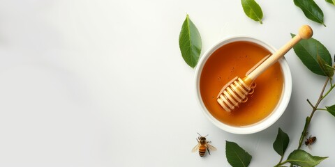 Wall Mural - jar of honey with honey stick and green leaves on light background