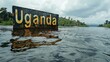 Scenic View of a Weathered Uganda Sign Emerging from a Tranquil Lake