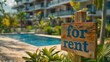 For Rent Sign Positioned Near A Modern Beachfront Condo Or Apartment Complex