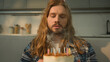 © Yuliia - Depressed isolated quarantine outcast lockdown sad upset frustrated Caucasian birthday man male guy blowing candles cake make wish wishing cake alone without friends family celebrate lonely at home