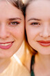Closeup of womens faces, smiling with glowing skin and sparkling eyes