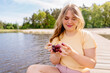 a woman is sitting on a dock eating grapes