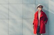 Fashionable senior posing in red coat outdoors