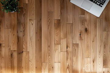 Natural wooden floor with a minimalist laptop setup and a vibrant plant, embodying a tranquil work environment