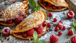 Delicious stuffed pancakes topped with powdered sugar, served with fresh raspberries and mint on a rustic wooden table