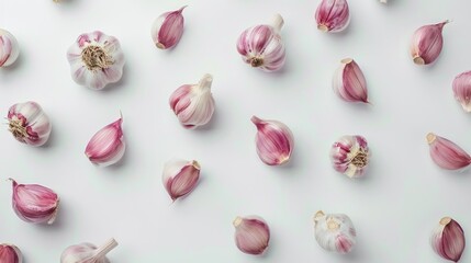 Garlic arranged on a white surface from a top perspective